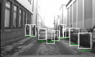 This photo shows true detections and typical false positives. People are tracked using white bounding boxes in an urban environment with snow covering the ground. The white boxes indicate possible pedestrian objects.