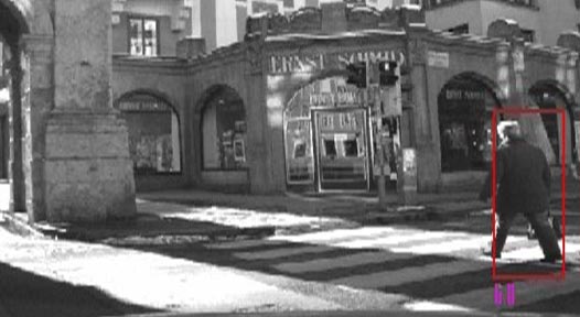 This photo shows a pedestrian walking across a crosswalk while a vehicle waits makes a right turn. The pedestrian is detected by the appearance classifier by a red bounding box.