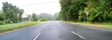 This photo shows 1 of 14 roadway panoramas presented to participants in the similarity rating task. Three lanes are visible in the direction of travel. A grassy median obstructs the view of the opposing lanes. Trees line the roadway on all sides. Thirty-five mi/h signs are in the median and on the right shoulder.