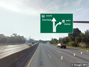This photo shows a split with an odd number of lanes on a five-lane highway. The lanes are numbered 1 through 5 from left to right, with 1 highlighted in blue. There is a sign above the roadway showing a five-lane up arrow labeled  94 South Fairview.  Two lanes (lanes 4 and 5) curve to the right and are labeled  24 West Claire.  The remaining three lanes (1 through 3) continue straight.