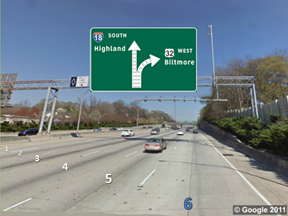 This photo shows a split with an even number of lanes on a six-lane highway. The lanes are numbered 1 through 6 from left to right, with 6 highlighted in blue. There is a sign above the roadway showing a six-lane up arrow labeled  18 South Highland.  Three lanes (4 through 6) curve to the right and are labeled  32 West Biltmore,  The remaining three lanes (1 through 3) continue straight.