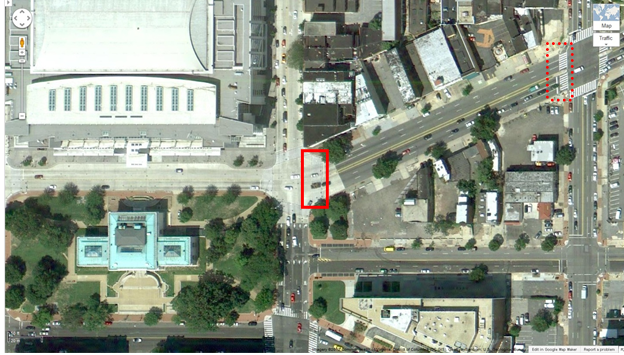 Aerial view of Location 2. The solid red rectangle highlights the intersection of 7th Street Northwest and New York Avenue Northwest. The dotted red rectangle highlights the intersection of 6th Street Northwest and New York Avenue Northwest in Washington, DC. The District of Columbia Department of Transportation camera was positioned facing east and captured pedestrians crossing north/south on New York Avenue Northwest between 7th and 6th Streets Northwest. The aerial view presents a mix of urban commercial property. A park and convention center are visible to the west side of the image.
