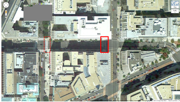 Aerial view of Location 5. The solid red rectangle highlights the intersection of 14th Street Northwest and H Street Northwest. The dotted red rectangle highlights the intersection of 15th Street Northwest and H Street Northwest in Washington, DC. The District of Columbia Department of Transportation camera was positioned facing west and captured pedestrians crossing north/south on H Street Northwest between 14th and 15th Streets Northwest. The aerial view presents a mix of urban commercial property.