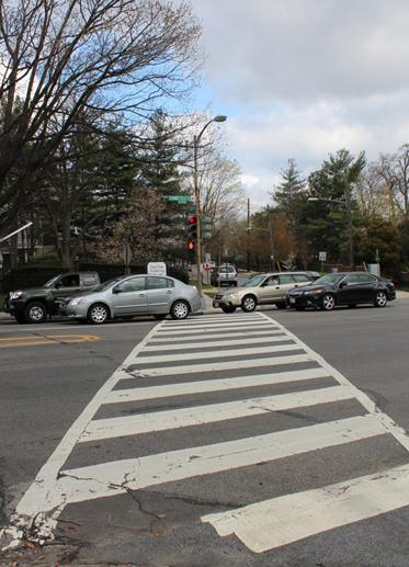 Illustration of what a pedestrian might see as he or she attempts to cross from the west side of Connecticut Avenue Northwest to the east side of the street along Oliver Street Northwest. The photo is taken from the pedestrian perspective. Several vehicles are traveling through the intersection.