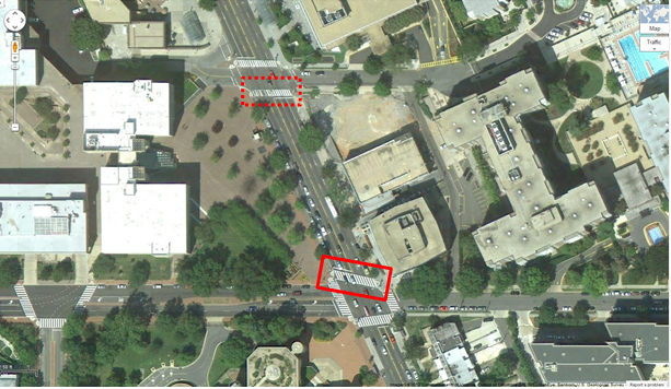 Aerial view of Location 10. The solid red rectangle highlights the intersection of Connecticut Avenue Northwest and Van Ness Street Northwest. The dotted red rectangle highlights the intersection of Connecticut Northwest and Veazey Terrace in Washington, DC. The District of Columbia Department of Transportation camera was positioned facing north and captured pedestrians crossing east/west on Connecticut Avenue Northwest between Van Ness Street Northwest and Veazey Terrace Northwest. The aerial view presents a mix of urban commercial property and a green walking space area to the west of the central roadway.