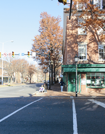 Illustration of what a pedestrian might see as he or she attempts to cross from the south side to the north side of King Street along North Washington Street in Alexandria, VA. The photograph is taken from the pedestrian perspective. A pedestrian who recently completed a crossing can be seen.