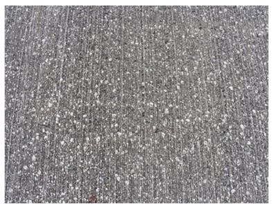 The photo shows a close-up of the  gray milled surface. It has white specks and is streaked with lines.