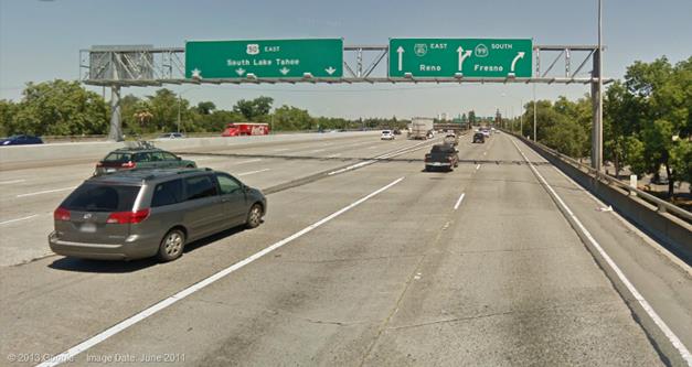 This photo shows vehicles on a highway. The highway has one direction sign where the destination name is placed above the arrow, and two direction signs where the destination names are placed beside the arrows.