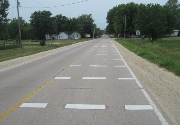 Figure 153. Photo. OSB variation, Iowa State University. This figure shows an illustration of variation of the optical speed bars as implemented by Iowa State University. This design consisted of three horizontal bars spaced at intervals so that drivers can position their vehicles within the wheel paths. 