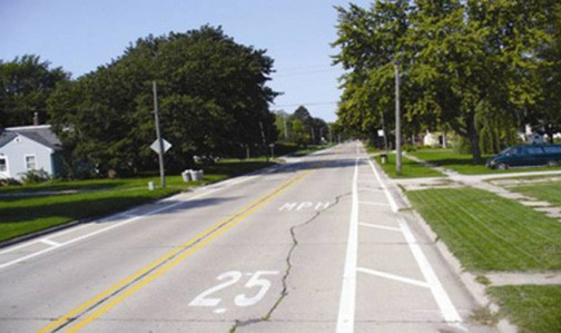 Figure 159. Photo. Add shoulder markings to narrow lane. This figure shows an example of shoulder markings added to narrow the lane width. Installing wide edgeline and crosshatch markings creates a shoulder on both sides of the roadway to reduce lane widths.