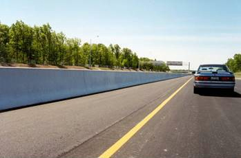 Figure 177. Photo. Roadside barriers. This figure shows an example of a rigid, concrete barrier placed along the side of the road, which is used to safely redirect vehicles from roadside hazards.