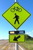 Figure 33. Photo. R-B, lap A study assembly. A Pedestrian and Bicycle Crossing sign assembly with a set of rectangular beacons between the W11-15 sign and the W16-7P arrow plaque.