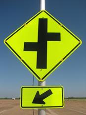 Figure 36. Photo. LED, lap B study assembly. An Offset Side Roads sign with yellow light-emitting diodes embedded in eight places (each corner and the midpoint of each side) on the black border of the sign and a W16-7P arrow plaque below the sign. Figure 36. Photo. LED, lap B study assembly. An Offset Side Roads sign with yellow light-emitting diodes embedded in eight places (each corner and the midpoint of each side) on the black border of the sign and a W16-7P arrow plaque below the sign.
