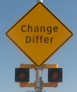 Figure 39. Photo. Discomfort glare assembly with circular beacons. A diamond-shaped warning sign with a set of 8-inch circular beacons below the sign. The sign reads “Change” on the first line and “Differ” on the second line.