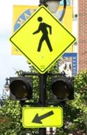 Figure 81. Photo. Circular beacons used at MK-05. A Pedestrian Crossing sign assembly with a set of circular beacons between the W11-2 sign and the W16-7P arrow plaque.