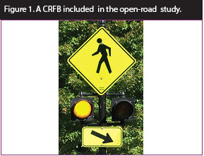 Figure 1. Photo. A CRFB included in open-road study. This photo features a pedestrian crossing sign assembly with a set of circular beacons between the W11-2 sign and the W16-7P arrow plaque.