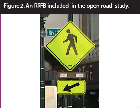Figure 2. Photo. An RRFB included in open-road study. This photo features a pedestrian crossing sign assembly with a set of rectangular beacons between the W11-2 sign and the W16-7P arrow plaque.