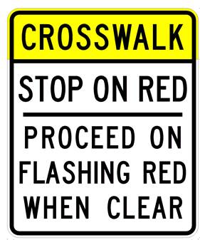 Figure 58. Photo. Sign recommended by FHWA to address comprehension issues with the flashing red phase. This photo shows a white rectangular sign with black borders. The top of the sign has a yellow header with black letters that read "CROSSWALK." The rest of the sign reads, "STOP ON RED PROCEED ON FLASHING RED WHEN CLEAR" in black lettering.