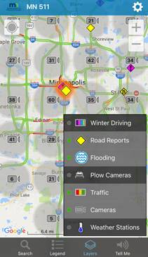 This screenshot shows a second view of the Minnesota Department of Transportation’s 511 mobile app. Similar to figure 8, the screen shows a Google® map that has various symbols on it, including yellow diamonds and purple diamonds with exclamation points. There are also gray circles throughout the map with numbered camera symbols within them. On the bottom of the screen are the same three buttons as in figure 9: search, legend, and layers. The layers button is selected. A pop-up menu on the bottom right shows (from top to bottom) the available layers: winter driving, which is a rectangle with dark purple, light purple, blue and green vertical lines inside it; road reports, which is a yellow diamond; flooding, which is represented by a blue circle containing blue wavy lines; plow cameras, which has a plow graphic; traffic, which has a rectangle containing red, yellow, and green vertical stripes; cameras, which is a camera symbol. There are green dots next to road reports, flooding, traffic, and cameras, indicating that those four layers are currently selected.