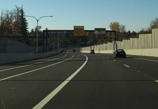 Photo. Washington State Route (SR) 520 westbound near 92nd Avenue northeast. This photo depicts two high-occupancy vehicle lanes on the left separated by a space roughly equal to the width of a lane. No traverse markings are provided. Upstream of this point, the downstream taper and convergence are not visible, and the area is easily mistaken for a lane.