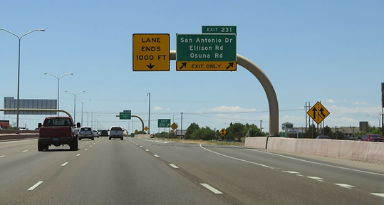 Escape lane signing that does not adhere to the consistency principle because the continuing lane is signed as an exit-only lane. This photo shows signing for a lane reduction at the point of the exit gore.