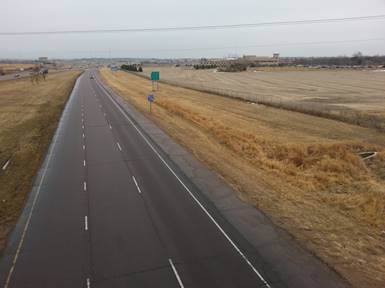 Photo. Left-hand acceleration lane terminating in a lane-reduction taper. The photo shows the marking pattern used along the entire length of a left-hand acceleration lane—a left entrance from another freeway.