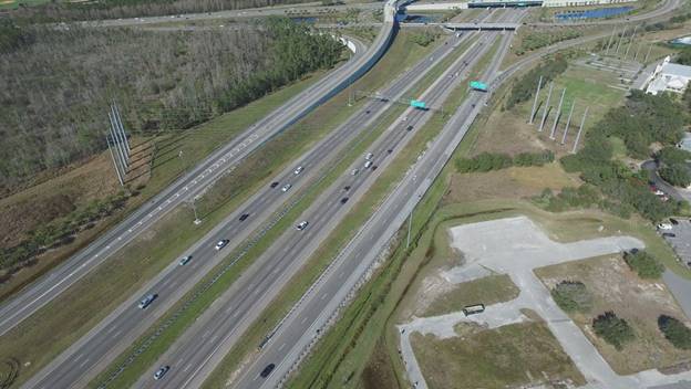 Photo. Example video still from camera 2 at site 11. This still from a single unmanned aerial vehicle video pictures four attributes: auxiliary lanes—attribute 4110; exiting lanes—attribute 4120; exit with downstream split—attribute 4222; and guide signs for option lanes—attribute 5130.