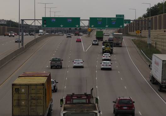 Photo. I-35W southbound approaching split 1, the three-lane ramp to the Minnesota TH 62 exits. This photo shows a split with signing including one guide on left with three down arrows, and a second on right with three angled down arrows.