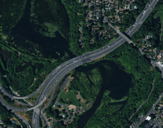 Photo. Aerial view of the interchange at site 43-2. This aerial photo consists of four lanes, with the rightmost lane being an exit-only lane, and the adjacent lane being an option lane.