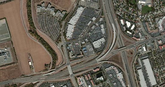 Photo. Aerial view of location 1. This aerial photo shows a key feature of an interstate interchange where both the high occupancy vehicle and tolling and general-purpose lanes occupy the same carriageway up to a split within the interchange.