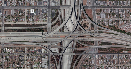 Photo. Aerial view of location 2. This aerial photo shows a modified four-level interchange between two interstates. All approaches feature a combination of option lanes, auxiliary lanes, and access to service interchanges within the interchange influence area. The high-occupancy vehicle and tolling exits are not out of sequence as the first exit is for westbound traffic, and the second exit is for eastbound traffic, consistent with right-hand and left-hand conventions.