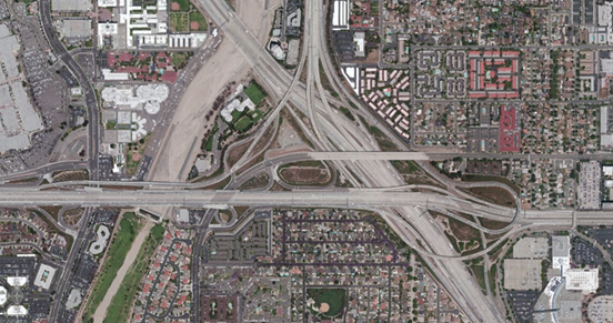 Photo. Aerial view of location 3. This aerial photo shows a five-way junction with access to numerous heavily traveled arterial routes. Exits conform to the first exit for right-hand movements sequencing method, with the exception of the freeway connection to the interstate, which is also served by heavy-occupancy vehicle direct-connection ramps for movements in the same cardinal direction only. The interchange features a redundant bypass lane for southbound traffic, intended for vehicles bound for a service interchange.