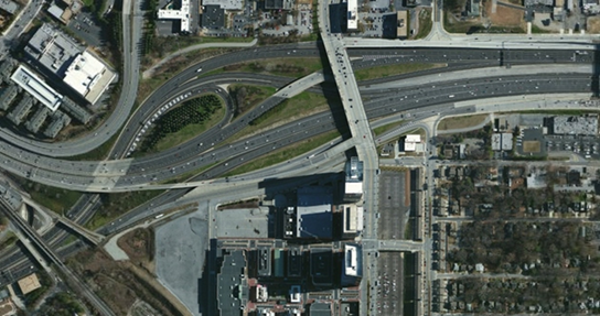 Photo. Aerial view of location 5. This aerial photo shows a major interchange split involving two interstates. The interchange places the movements in the left and right lanes.
