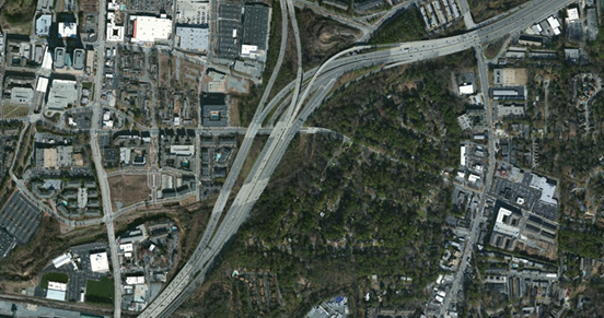 Photo. Aerial view of location 7. This aerial photo features a collector–distributor roadway in the form of a parallel multilane facility. This collector is largely inaccessible from the interstate. Northbound lanes feature a four- to three-lane two-lane split. Two heavy-occupancy vehicle-only ramps serve a local facility within the interchange area, with access to and from the northeast only. Two heavy-occupancy vehicle-only ramps serve a local facility within the interchange area, with access to and from the northeast only.