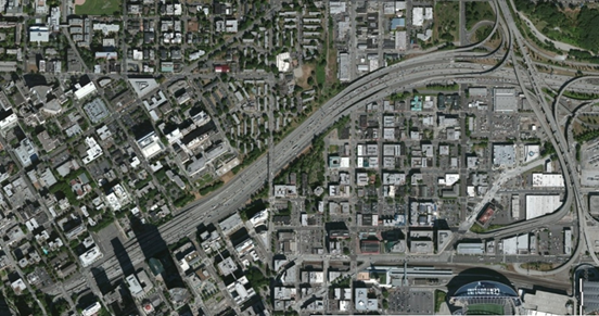 Photo. Aerial view of location 12. This aerial photo shows an interchange of mid-1960s vintage, with interstate access in the southbound direction having been moved. Planned improvements include northbound freeway-to-freeway ramp metering, a reconfiguration of the northbound mainline lanes to permit two entering lanes from the collector–distributor roadway, and other changes to local access.