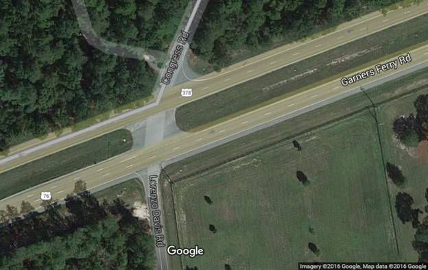 Bird’s-eye view of a rural four-legged, stop-controlled intersection. The major roadway is a four-lane divided highway with no traffic control. The intersecting roadways from the north and south are stop controlled.