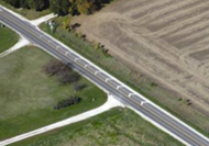 This is an aerial photo of a road with white chevrons installed in a series to give drivers the illusion of driving faster.