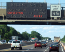 This is a photo of a highway with three lanes of traffic headed in the same direction. Above the traveling vehicles is a dynamic variable message sign and a separate digital speed limit sign. The dynamic variable message sign displays traffic information and the speed limit sign displays the current speed limit. The signs in this photo read as follows: 'CONGESTION AHEAD,' and 'SPEED LIMIT 45.'