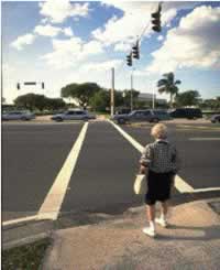 Figure 34. Some pedestrians, such as this elderly women pictured looking out toward a long crosswalk across a multi-lane road and busy intersection, are not able to cross within the signal time provided