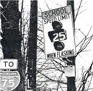 Figure 38. School regulatory flashes, such as the one posted on this pole along a road near a school, have been found to have only limited success in reducing vehicle speeds in school zones, unless adult crossing guards are also helping to control traffic