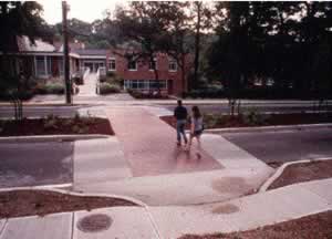 Figure 44. Two pedestrians using a crosswalk with a  traffic-calming device. It reduces vehicle speeds or volumes, and/or shortening crossing distances for pedestrians.