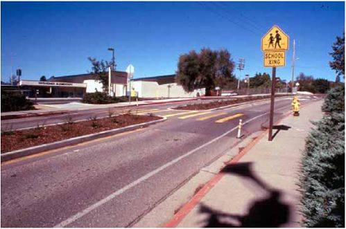 The sign and crosswalk markings at this midblock crossing alert drivers to pedestrians going to school.