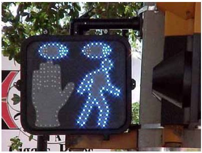 The animated eyes display has two lighted blue eyes at the top of the box, a hand (not yet flashing) on the left side, and LED lights outlining a pedestrian on the right.