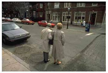 Reduced visibility of pedestrians behind parked cars can create conflict.