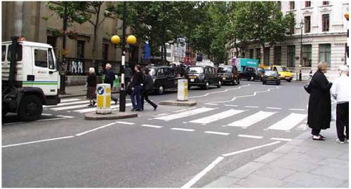 Zebra crossing in London, U.K., with zigzag approach markings and Belisha beacons.