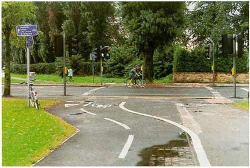 Toucan crossing in the United Kingdom provides separate pedestrian and bicyclist signal indications where trail crosses the road.