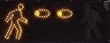 The animated eyes display has two lighted blue eyes at the top of the box, a hand (not yet flashing) on the left side, and LED lights outlining a pedestrian on the right.