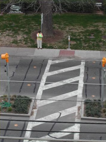 This photo is a close up of a signal pole with a pedestrian countdown signal that has an outline of a hand and the number "1" to the right of the hand, indicating that there is one second left to cross the intersection safely.