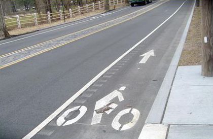 This picture shows a bike lane which has rumble strips along the left edge. Accompanying text says 'AVOID THIS! (rumble strips in bike lane)'.