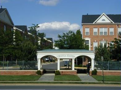 Picture shows a large, attractive bus stop shelter in front of a townhouse/apartment complex.